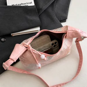 Dettaglio della borsa in seta rosa con interno spazioso e ricamo floreale
