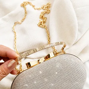 Close-up of golden sequin evening bag featuring a metal handle and bow clasp detail