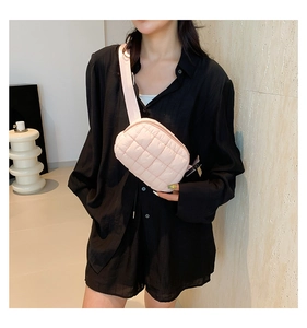 Detailed close-up of pink quilted pleated waist bag with adjustable nylon strap for women