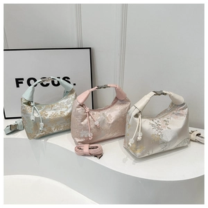 Trois sacs hobo en jacquard bleu, rose et blanc avec motifs floraux et pompons décoratifs
