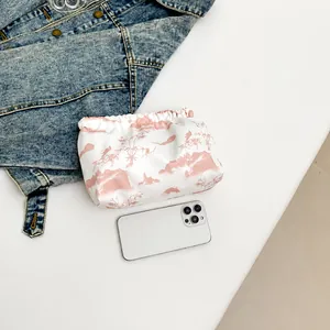 Detail der Nylon-Kordelzugtasche mit rosa Landschaftsdruck und Smartphone-Vergleich