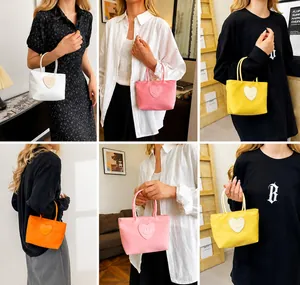 Modella che indossa borse in nylon con cuore sorridente in bianco, rosa e giallo