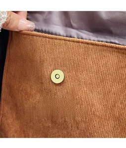 Détail du fermoir magnétique doré et de la doublure en satin sur le sac en velours