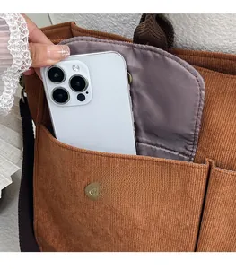 Détail du sac fourre-tout en velours côtelé avec poches avant pour smartphone