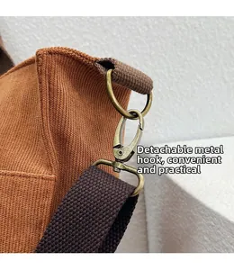 Détail du crochet en métal bronze antique et bandoulière amovible du sac cabas tissé brun