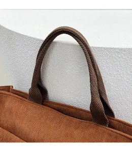 Détail du sac cabas en velours côtelé marron avec anses tissées et texture rayée