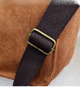Détail de la bandoulière tissée marron sur cabas en velours côtelé avec boucle métal