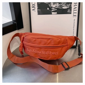 Détail du sac banane de sport orange vif avec broderie et sangle réglable