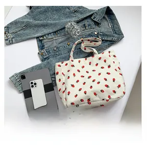 Détail du sac fourre-tout en velours côtelé blanc avec motif de fraise brodé