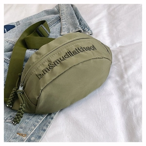 Sac banane en nylon vert olive avec broderie sur fond en denim décontracté