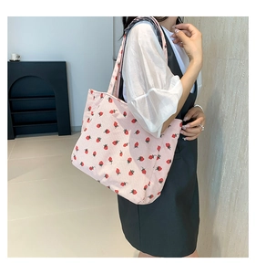 Détail du sac cabas en velours côtelé rose avec motif de fraises rouges imprimé