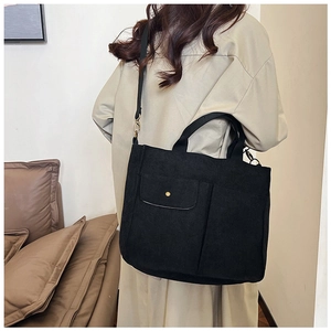 Vue détaillée du sac cabas en toile noire avec multi-poches et bandoulière réglable