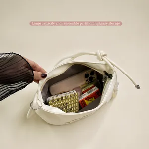 Vista detallada del interior espacioso de un bolso bandolera blanco bordado con cremallera