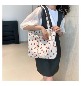 Détail du sac cabas en velours côtelé blanc avec imprimé fraises sur l'épaule