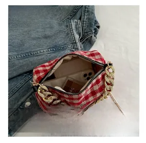 Vue intérieure montrant la capacité du sac en tweed rouge et blanc avec accessoires