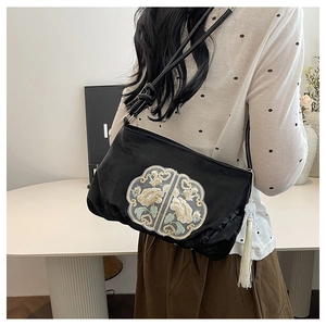 Detail of black velvet crossbody bag with traditional Chinese floral embroidery and tassel