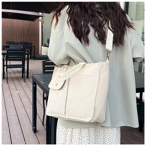 Détail du sac cabas en toile blanc cassé avec poche à pression et bandoulière