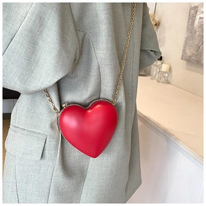 Détail du mini sac bandoulière rouge en forme de cœur avec fine chaîne dorée