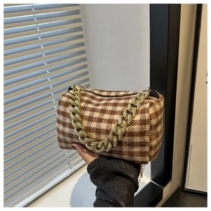 Détail du sac à main cylindrique avec tissu en laine pied-de-poule et chaîne dorée