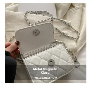 Detail shot of the white quilted crossbody bag featuring a reliable magnetic snap closure