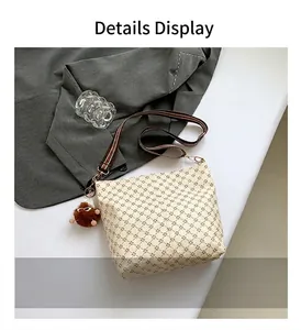 Detail view of cream Boston bag with geometric pattern and striped fabric shoulder strap