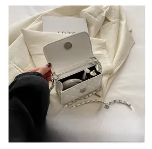 Detailed interior view of white quilted crossbody bag showing storage for makeup items