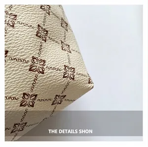 Close-up of off-white lychee grain leather texture with brown star floral patterns