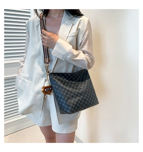 Detailed view of casual tote bag with geometric print, wide strap and plush bear charm