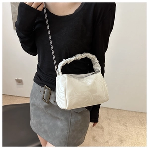 Detail of white marble textured handbag featuring ruched handle and silver chain strap