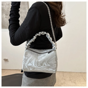 Detailed view of silver marble textured shoulder bag with pleated handle and chain
