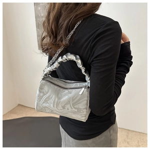 Detail of silver marble textured handbag featuring pleated cloud handle and metal chain