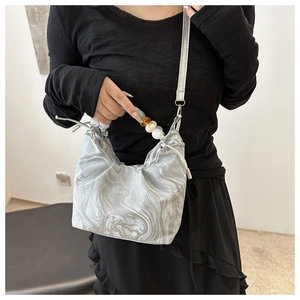 Detail van handtas met marmerpatroon met kleurrijke kralen en verstelbare schouderriem