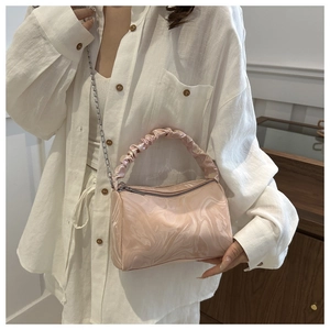 Close-up of pink marble pattern handbag with ruched handle and silver chain detail