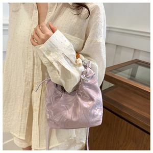 Detail view of a lavender marble-pattern bucket bag with amber and cream bead handles