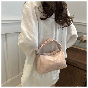 Detail of light pink marble pattern handbag with pleated handle and silver chain strap