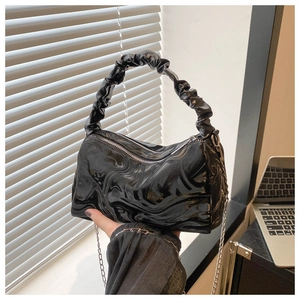 Detail of black glossy marble textured handbag with pleated handle and metal chain strap