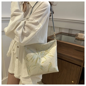 Close-up of bamboo and bird prints on a lace-style Chinese water bucket bag detail