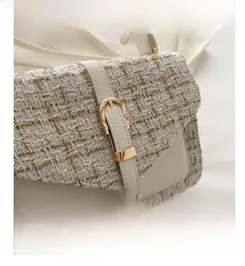 Detail of tweed and leather shoulder bag with gold thread and metallic buckle