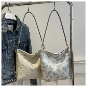 Detail of embroidered shoulder bags with delicate bamboo and butterfly patterns