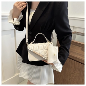 Detail of white quilted crossbody bag with gold metal trim and detachable coin purse