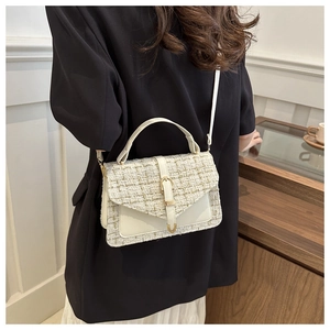 Detail of cream tweed crossbody bag with gold thread texture and metallic buckle