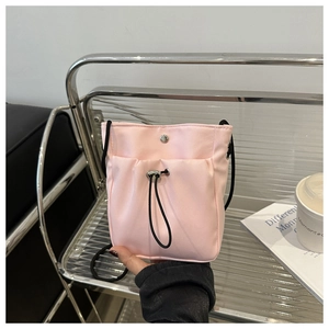 Detail van roze nylon telefoontasje met verstelbaar trekkoord en metalen drukknoop