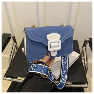 Details der blauen Canvas-Umhängetasche mit gemustertem Gurt und Metallkette