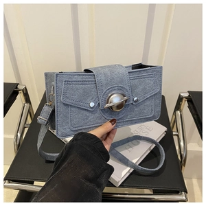 Détail du sac en denim bleu avec boucle en métal planète argentée et rivets décoratifs