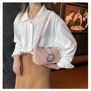 Detail of pink shoulder bag with glossy crinkled texture and silver square metal buckle