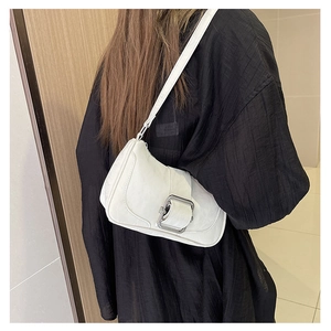 Close-up of cream white leather shoulder bag featuring decorative silver metal buckle