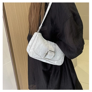 Close-up of metallic silver pleated underarm bag with decorative metal buckle and slim strap