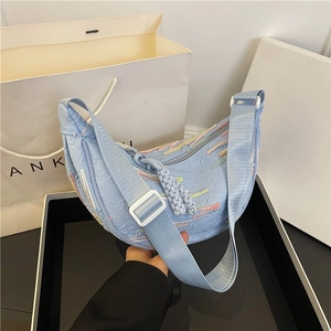 Light blue crescent moon crossbody bag with striped weaving and pleated texture detail