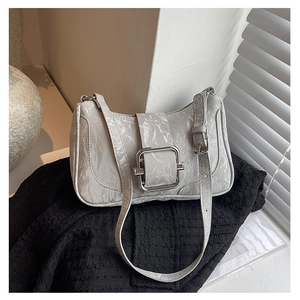 Close-up of light gray wrinkled leather shoulder bag with bold silver square buckle