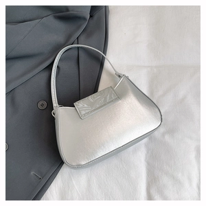 Detail der silbernen Metallic-Achseltasche mit Marmor-Akzent auf grauem Anzug
